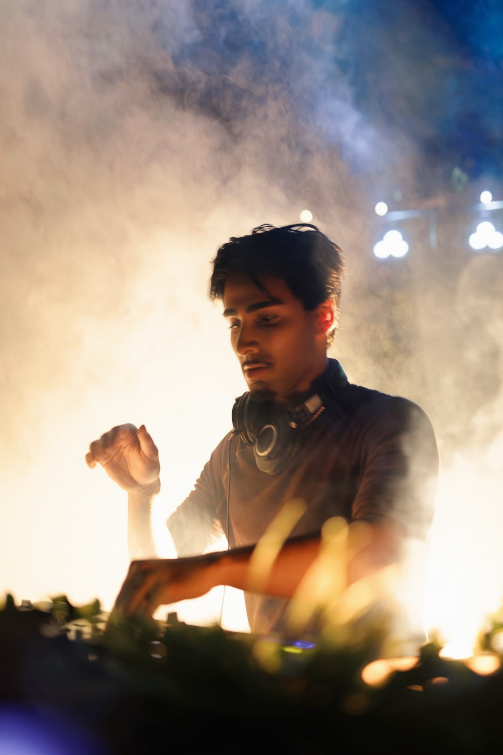 Armaan Damani performing a live set backlit by stage haze in San Diego