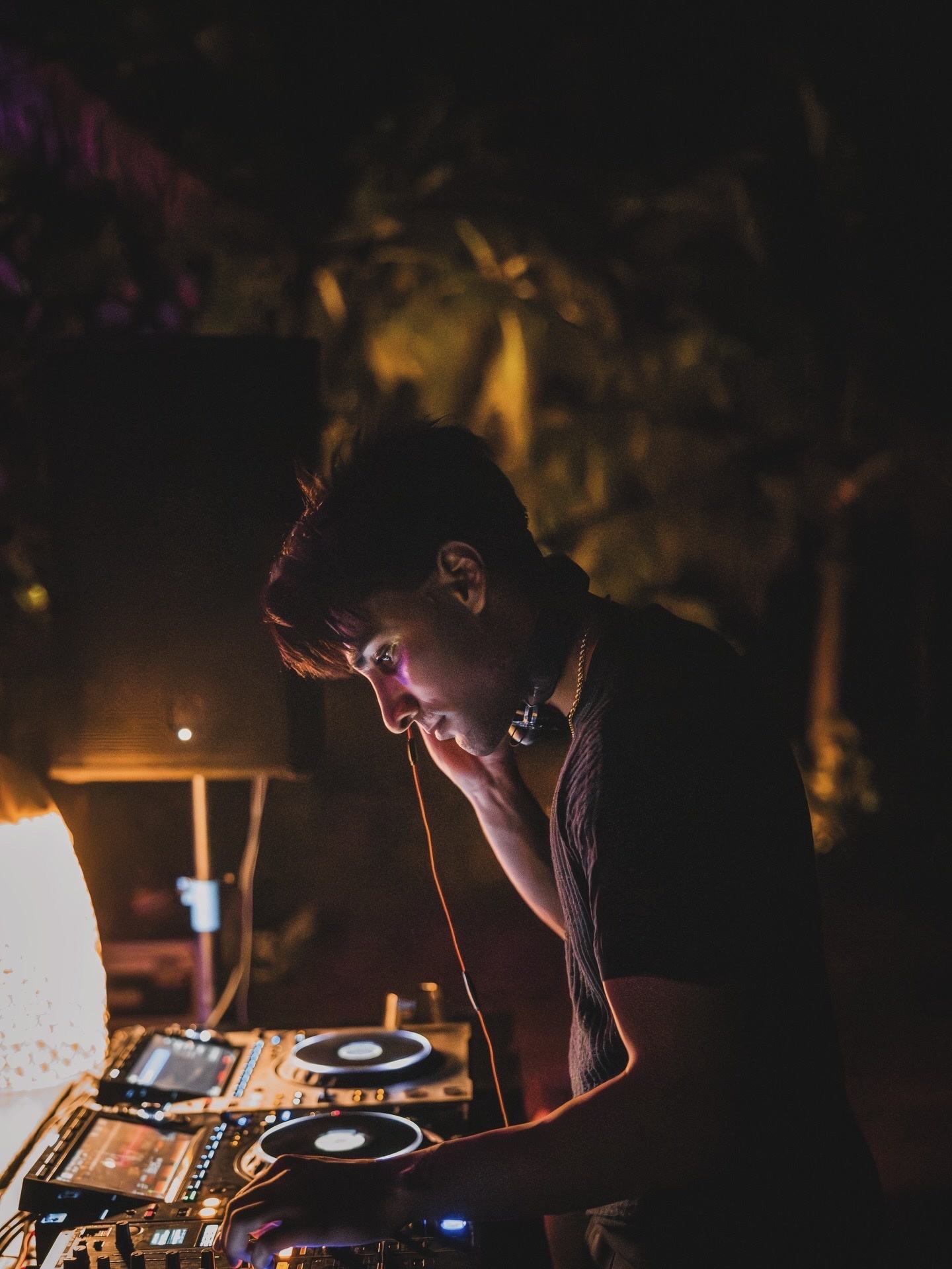 Armaan Damani cueing a late night melodic house set behind lit CDJs